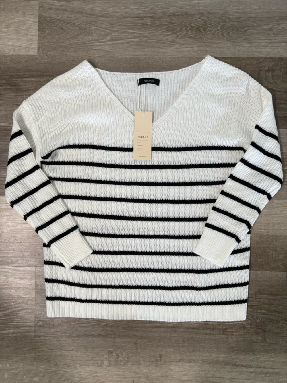 Dokotoo white and black striped knit sweater in women’s size medium.